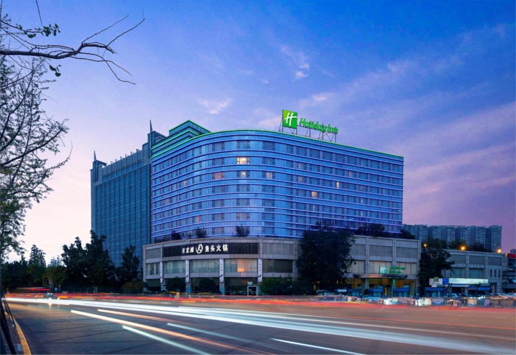 un gran edificio con un cartel de neón encima en Holiday Inn Chengdu Century City - East, an IHG Hotel, en Chengdú