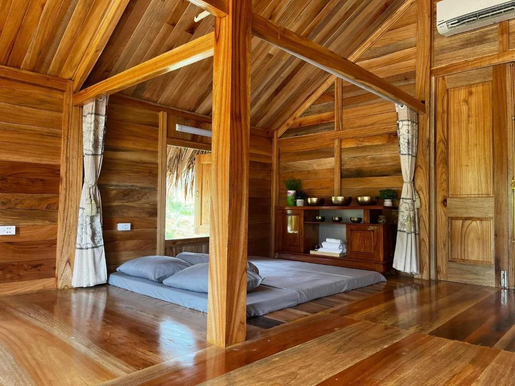 ein Schlafzimmer mit einem Bett in einem Holzzimmer in der Unterkunft Na Tuệ An-Homestay 81 Võ Văn Kiệt in Tuyên Quang