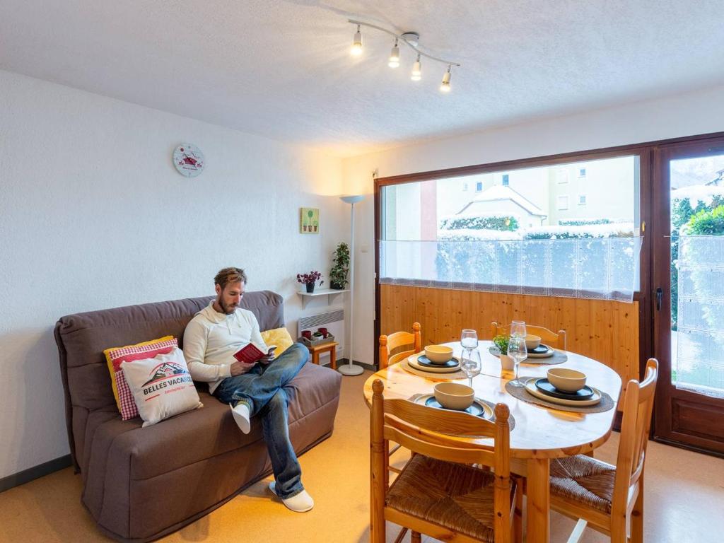サン・ラリー・スランにあるAppartement Saint-Lary-Soulan, 2 pièces, 6 personnes - FR-1-296-173の居間で本を読むソファに座る男