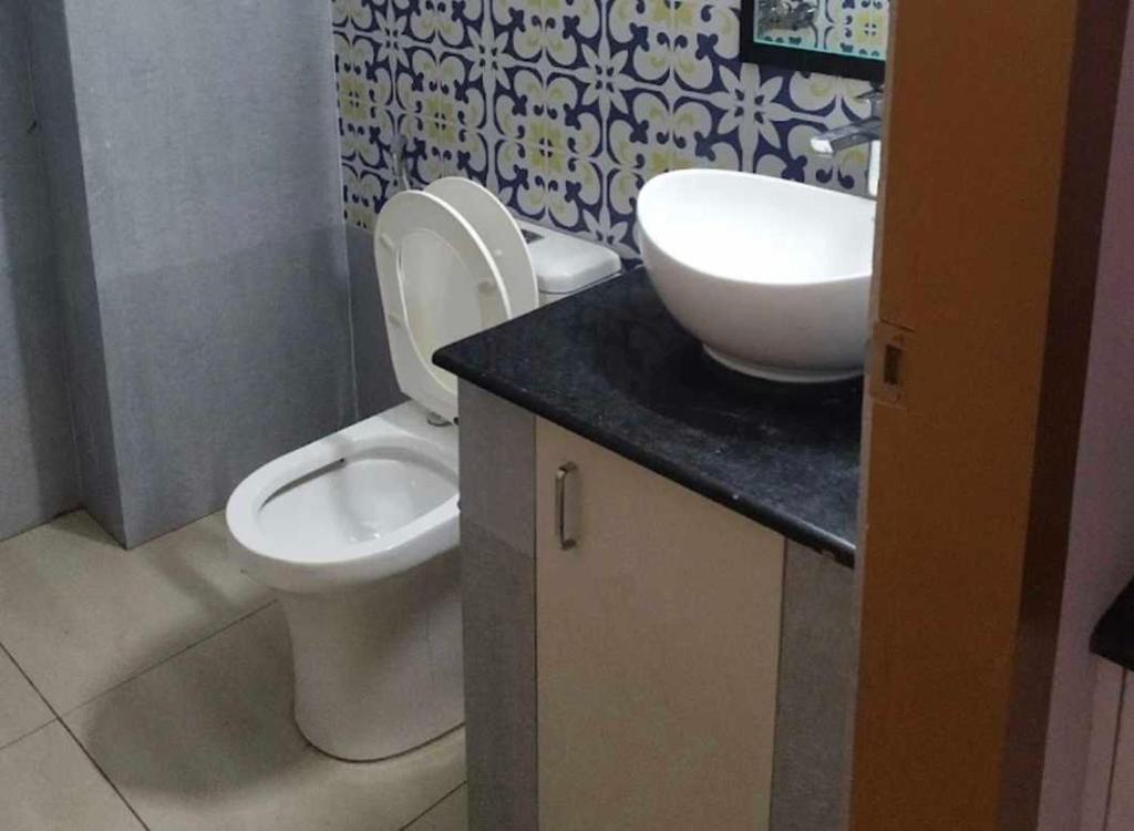 a bathroom with a white toilet and a sink at OYO Kailath Safe Stay Tourist Home in Thekkady