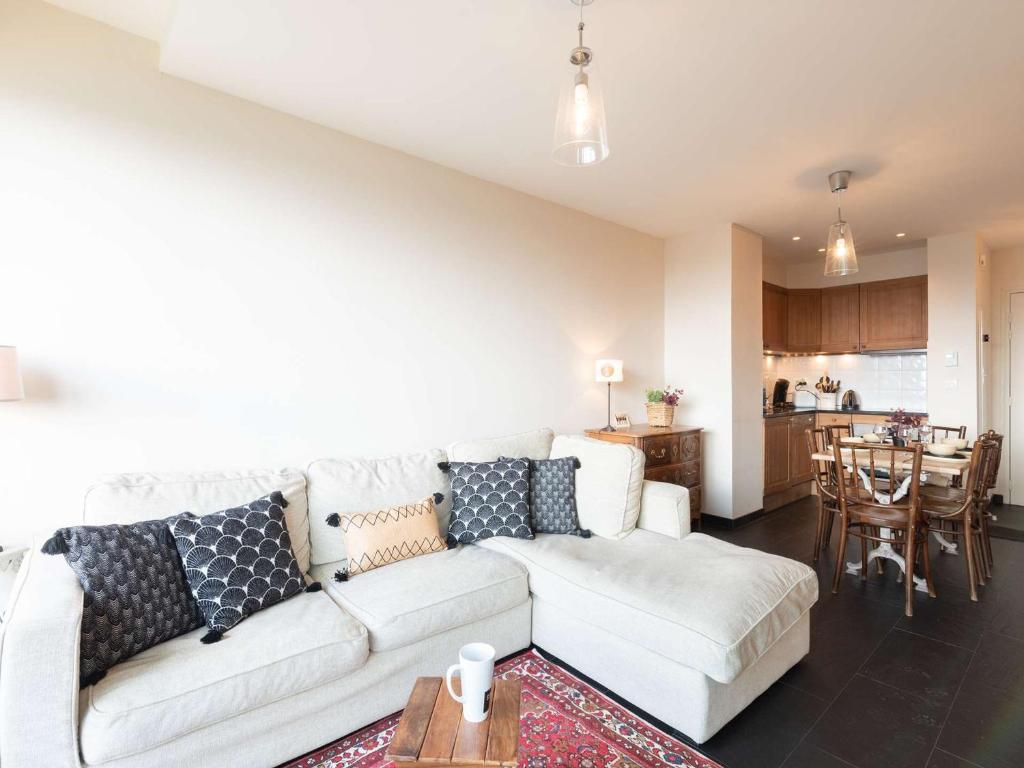 un salon avec un canapé blanc et une cuisine dans l'établissement Appart 7p Pieds de Pistes avec Piscine Chauffée - FR-1-296-345, à Saint-Lary-Soulan