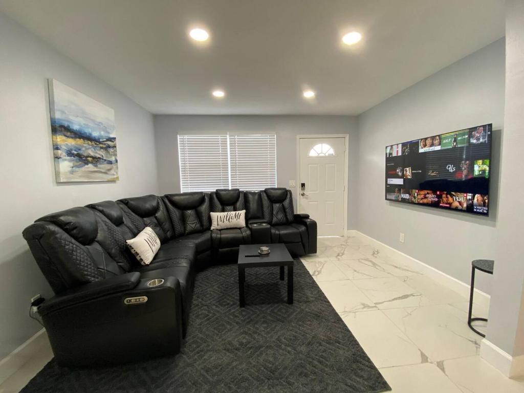 a black leather couch in a living room at Mazor Luxury Three Bedrooms Vacation Home in Fort Lauderdale