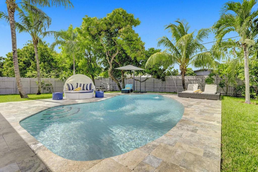 a swimming pool in a yard with palm trees at Yehudas Tropical Villa with Heated Infinity Pool in Hollywood