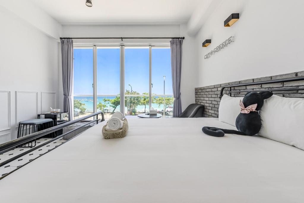 a bedroom with a large bed with a view of the ocean at Cat at Greece in Nanwan