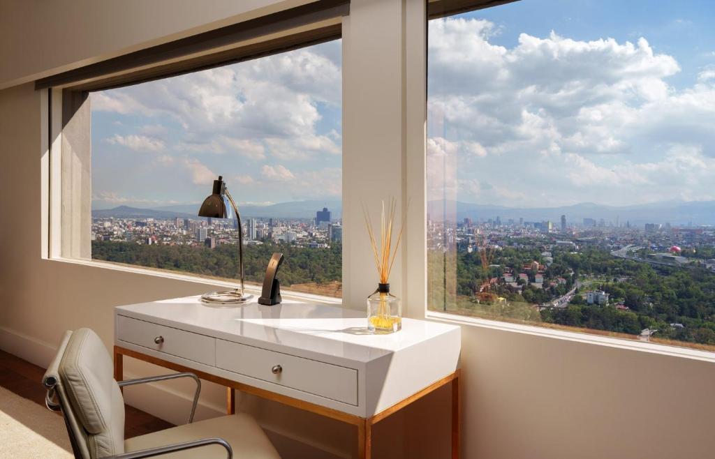 A window-side writing desk overlooking Mexico City and distant mountains.