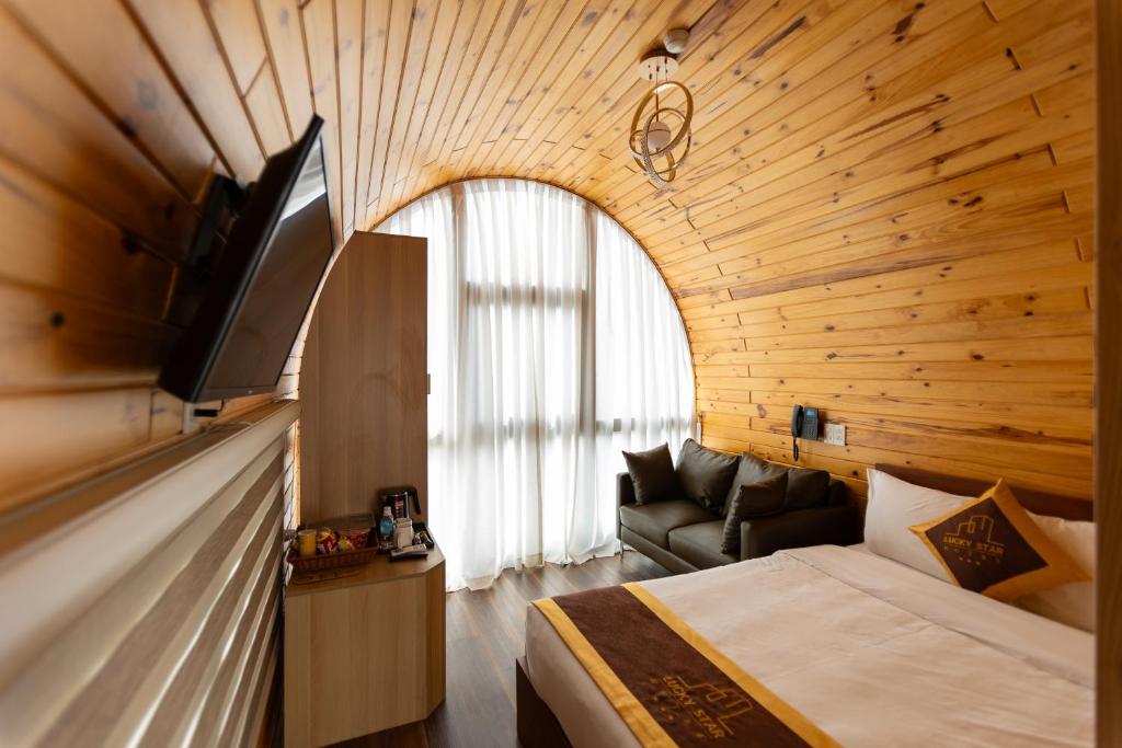 Habitación de hotel con cama y TV de pantalla plana. en LuckyStar Hotel en Pleiku