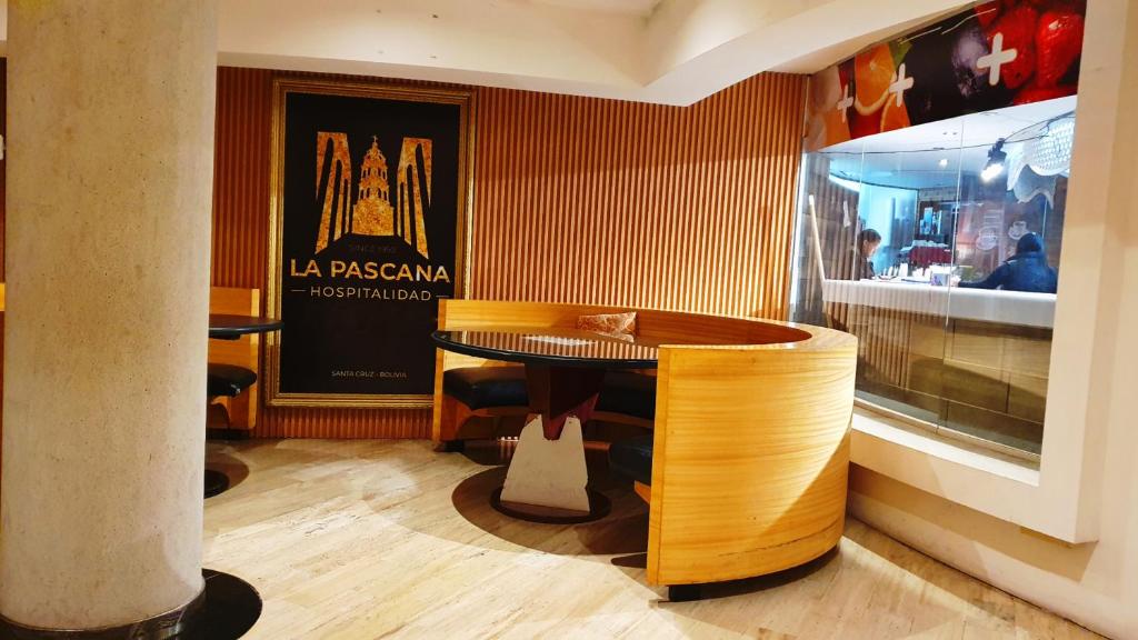 ein Restaurant mit einem Holztisch und einer Theke in der Unterkunft Pascana Hotel in Santa Cruz de la Sierra