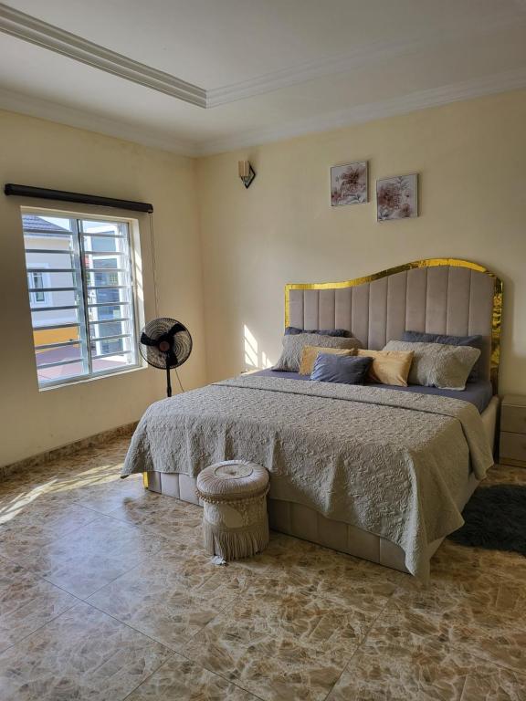ein Schlafzimmer mit einem großen Bett und einem Fenster in der Unterkunft Dvyne Luxury Home in Ikeja