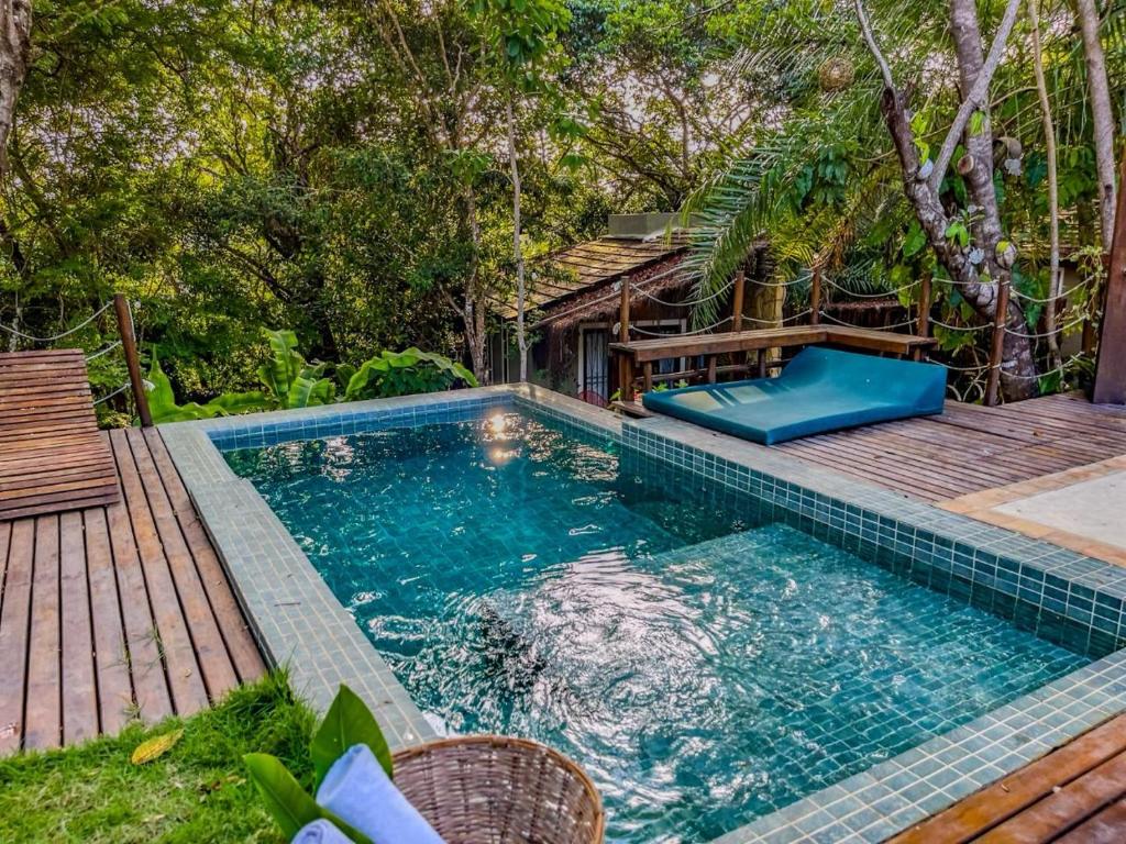 una piscina con terraza de madera junto a una casa en SITIO VILLA DA MATA en São Miguel dos Milagres
