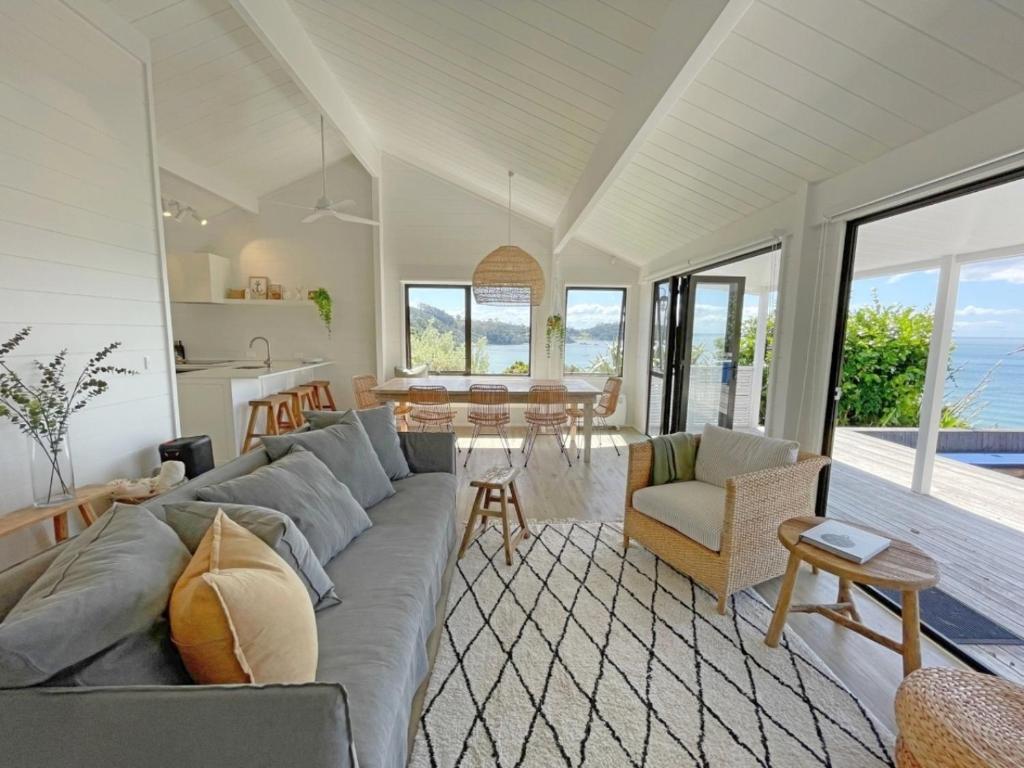 uma sala de estar com um sofá e uma mesa em Sea View Estate - Waiheke Escapes em Onetangi