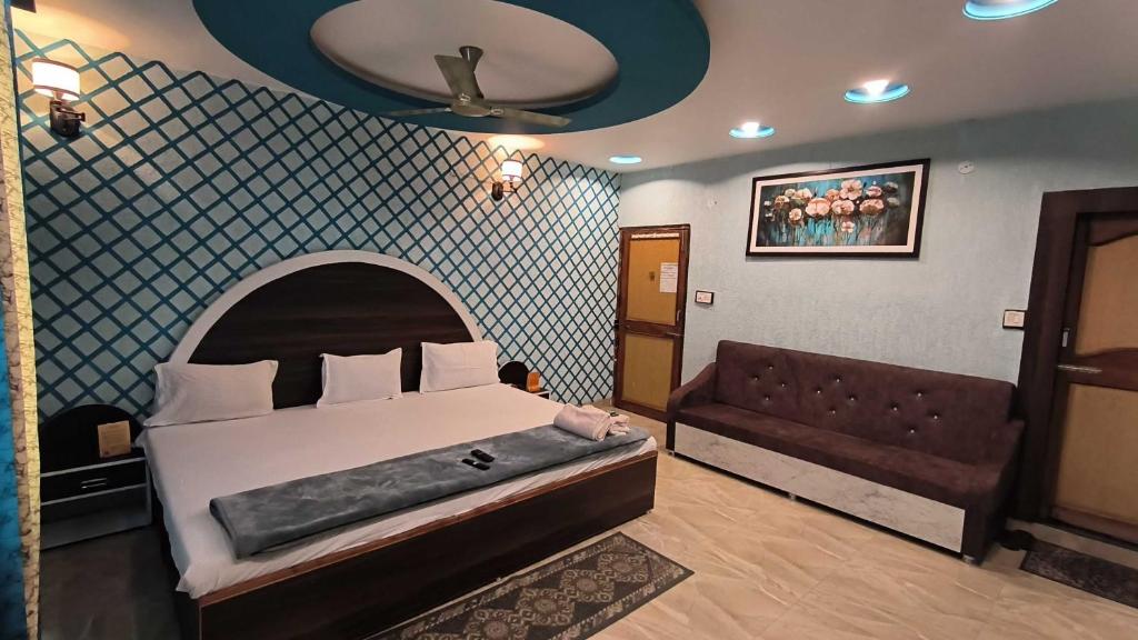 ein Schlafzimmer mit einem Bett und einem Sofa in der Unterkunft SPOT ON Pachmarhi Hills in Pachmarhi