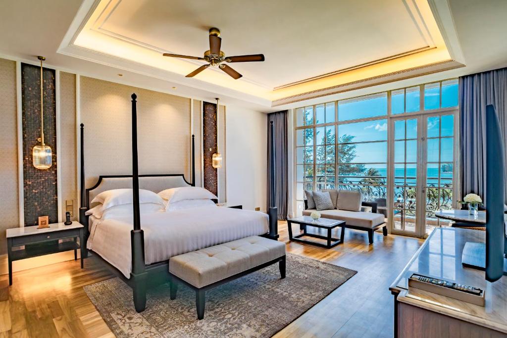 The Danna Langkawi - A Member of Small Luxury Hotels of the World في بانتاي كوك: غرفة نوم مع سرير وغرفة معيشة