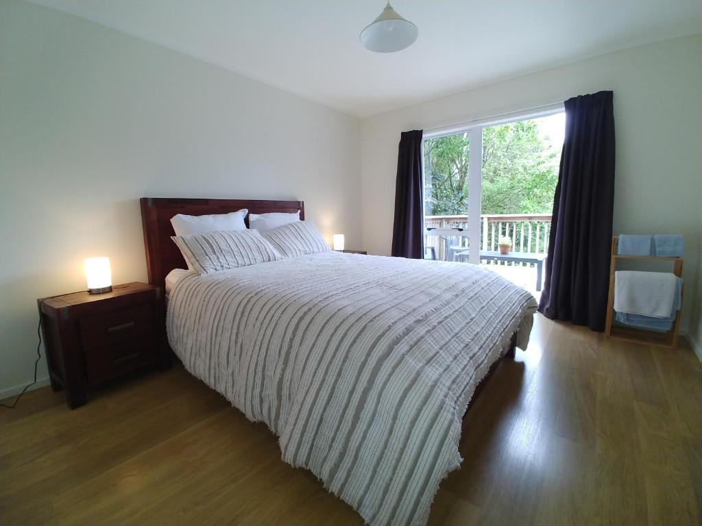 a bedroom with a large bed and a window at Comfortable 2-bedroom unit close to Hamilton, New Zealand in Hamilton