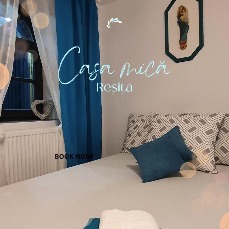 a bedroom with a bed with a blue sign on the wall at Casa mica Resita in Reşiţa