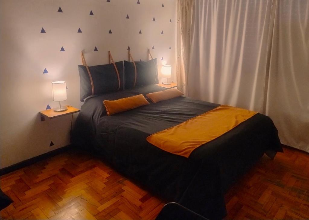 Apartment City Heart III في ميندوزا: غرفة نوم بسرير كبير فيها مصباحين