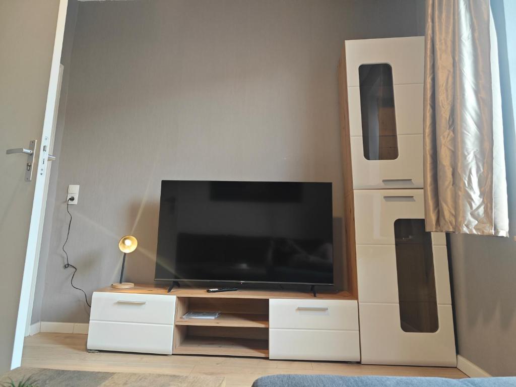 a entertainment center with a flat screen tv in a living room at Work and Stay 8 Betten 1 Küche 1 Badezimmer 150qm in Geilenkirchen