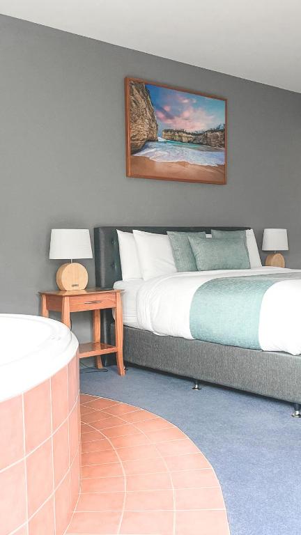a bedroom with two beds and a painting on the wall at Waves Luxury Suites in Port Campbell