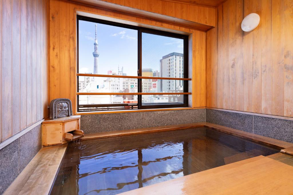 una piscina d'acqua in una stanza con finestra di Ryokan Asakusa Shigetsu a Tokyo