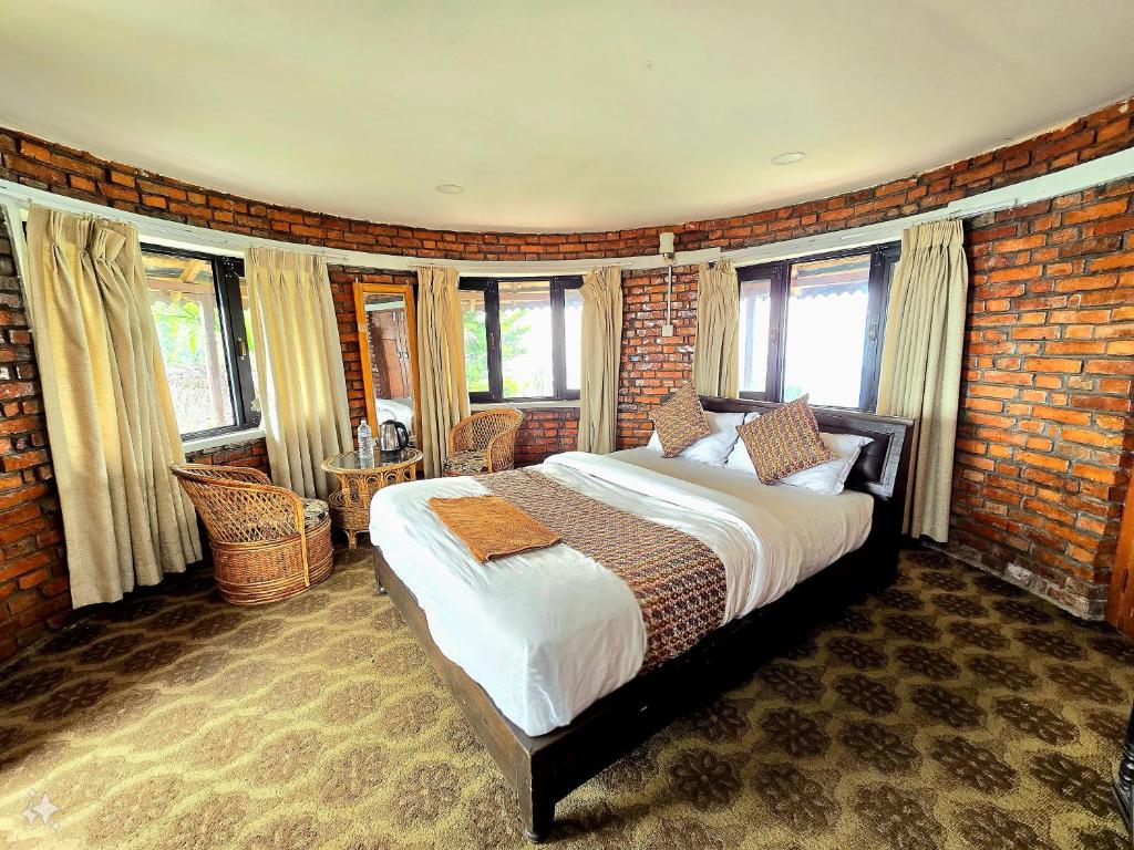 a bedroom with a large bed in a brick wall at Rock Garden Resort in Pokhara