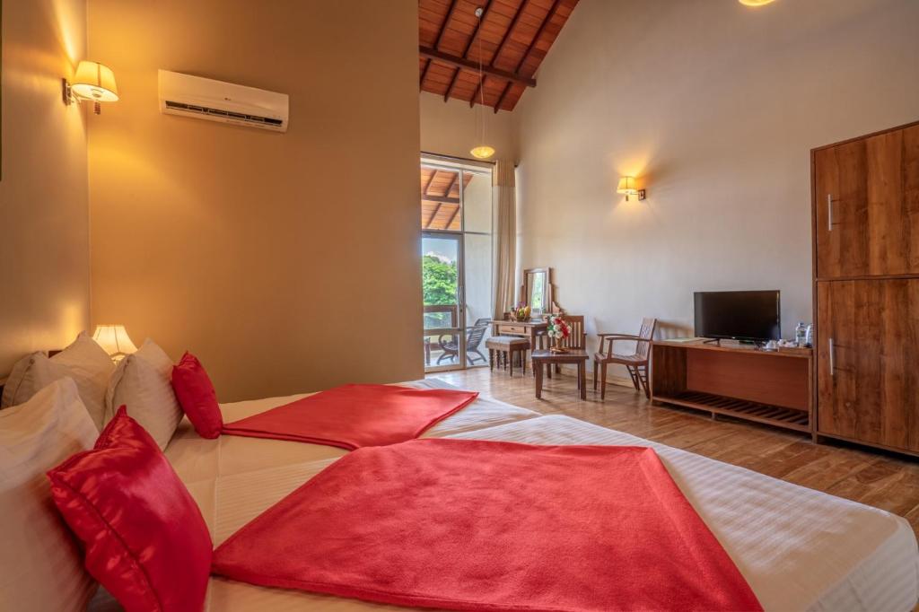 1 dormitorio con 1 cama grande con almohadas rojas en Lavendish Wild Wilpattu, en Nochchiyagama
