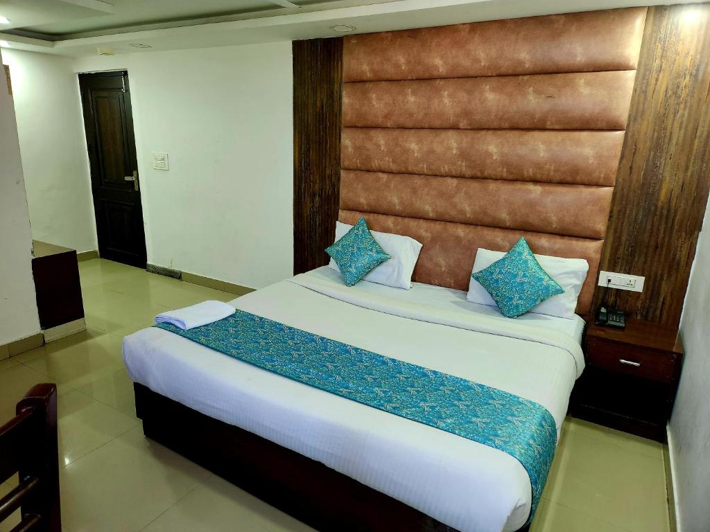 Hotel Marina Near IGI Airport Delhi في نيودلهي: غرفة نوم بسرير كبير مع وسائد زرقاء