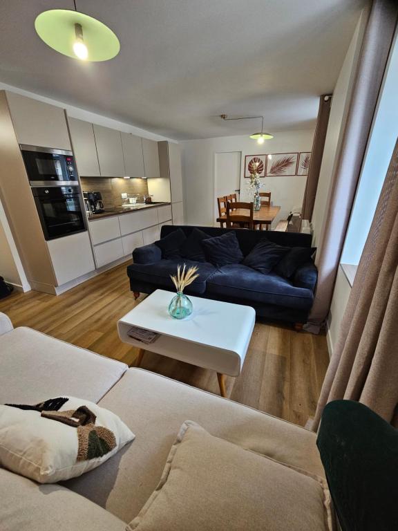 a living room with a couch and a table at Appartements 4, 5 et 10 personnes rénovés en centre-ville in Mont-Dore