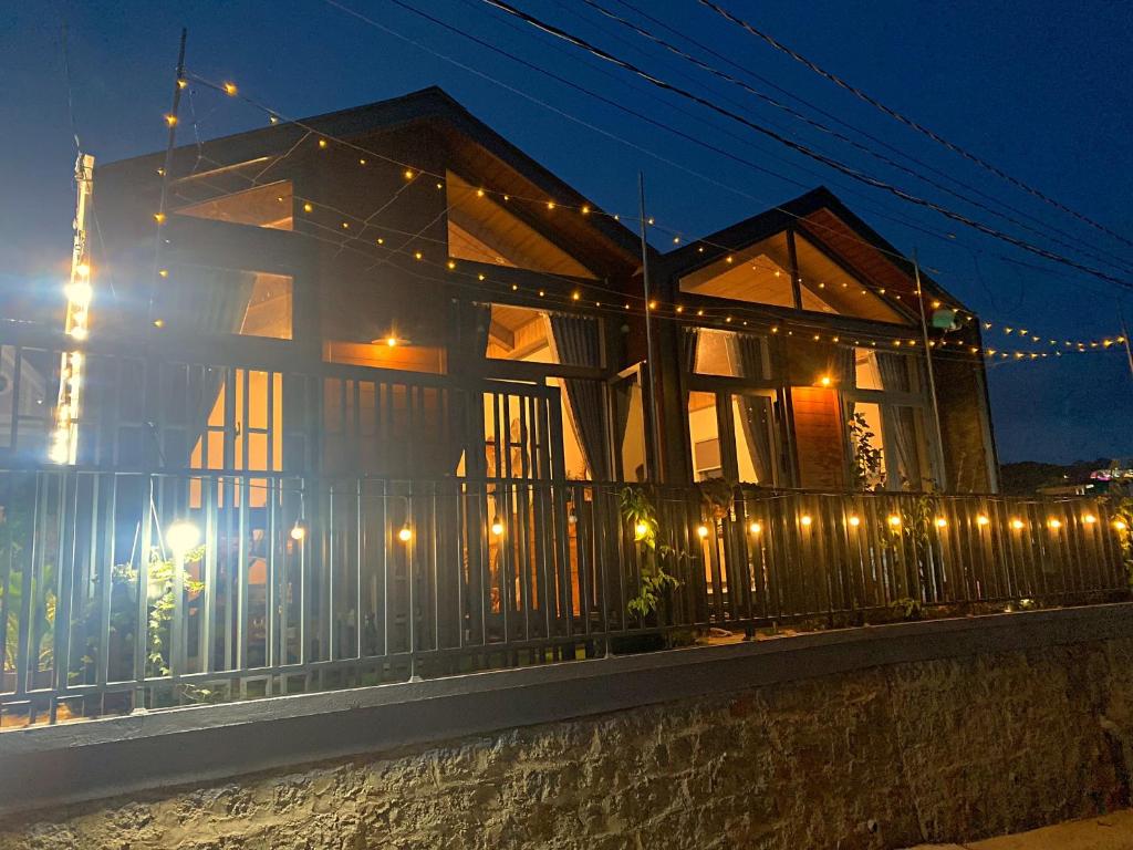 uma casa com luzes numa cerca à noite em Moon Homestay TWO em Xuan An
