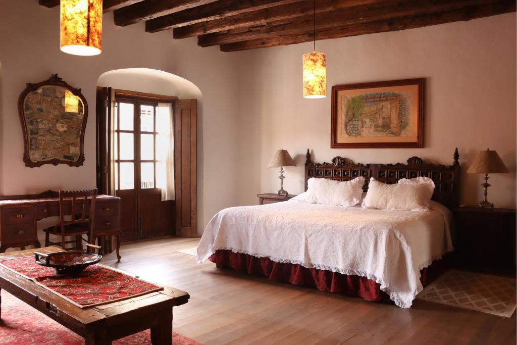 a bedroom with a large bed and a table at Mesón de la Abundacia in Real de Catorce