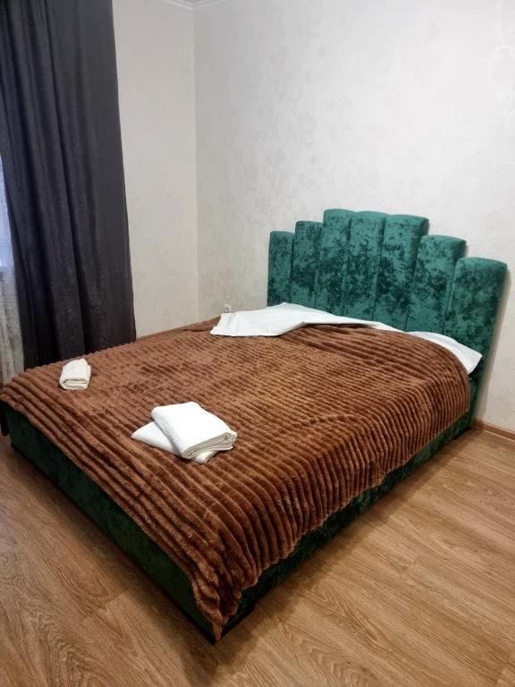een slaapkamer met een bed met een groene stoel bij Port City apartment in Loetsk