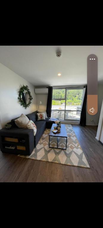 a living room with a couch and a table at Park Views, Close to town in Queenstown