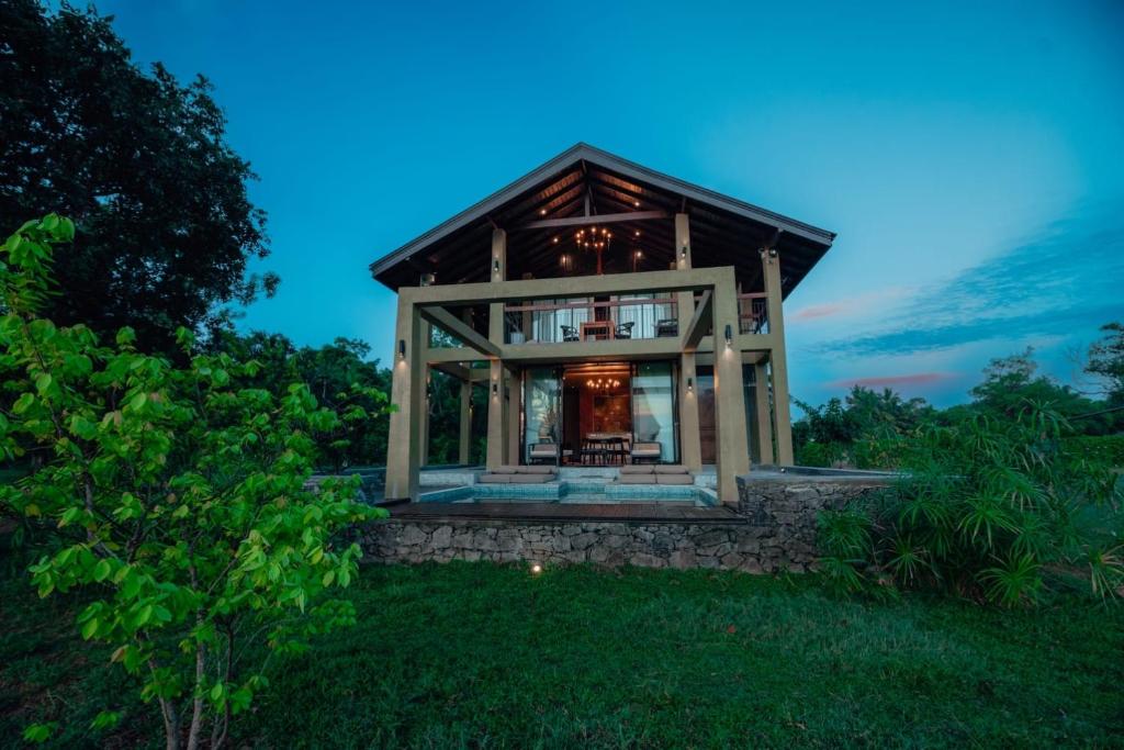 a house with a glass facade on a lawn at The Villa Lakeshore in Anuradhapura