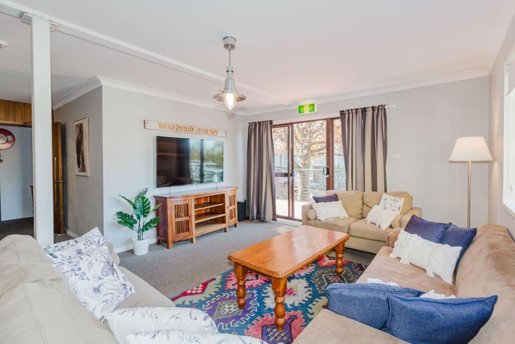 a living room with a couch and a table at Blizzard Bunny Lodge 43 Gippsland Street in Jindabyne