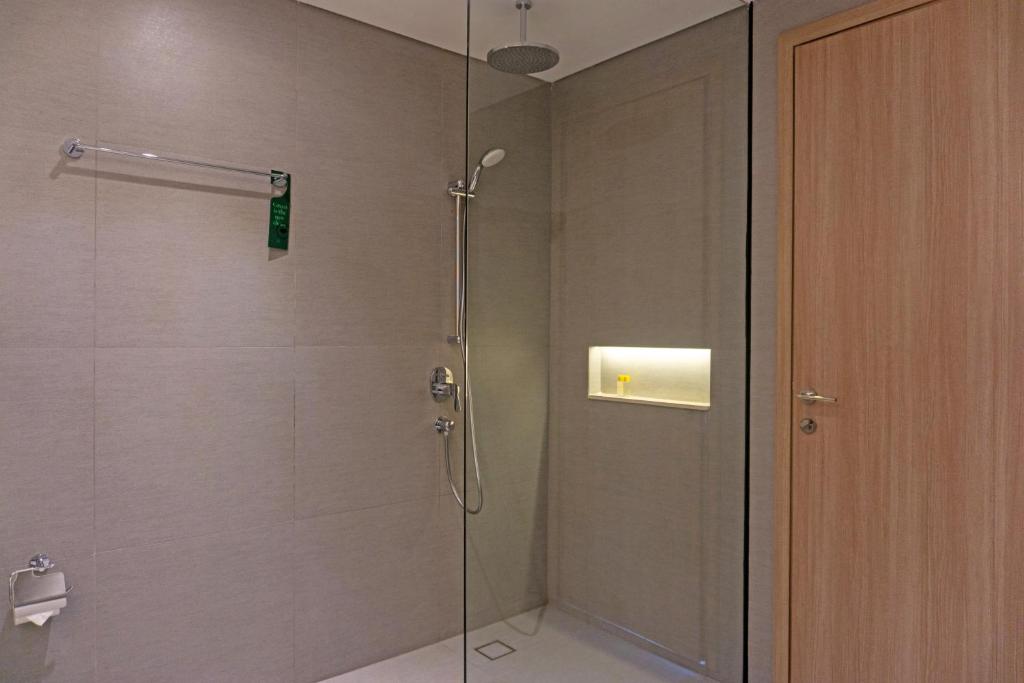 a shower with a glass door in a bathroom at Golden Tulip Springhill Lampung in Bandar Lampung