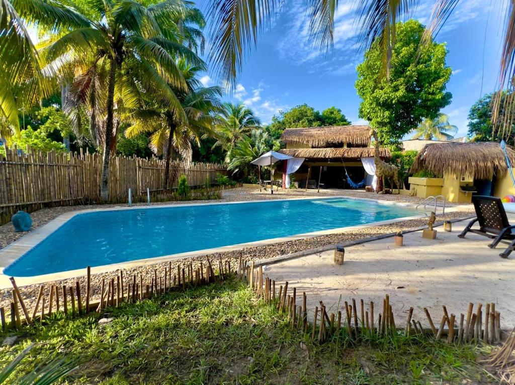 una piscina en un complejo con palmeras en Lujosa Mansión Tipo Bali, en Melgar