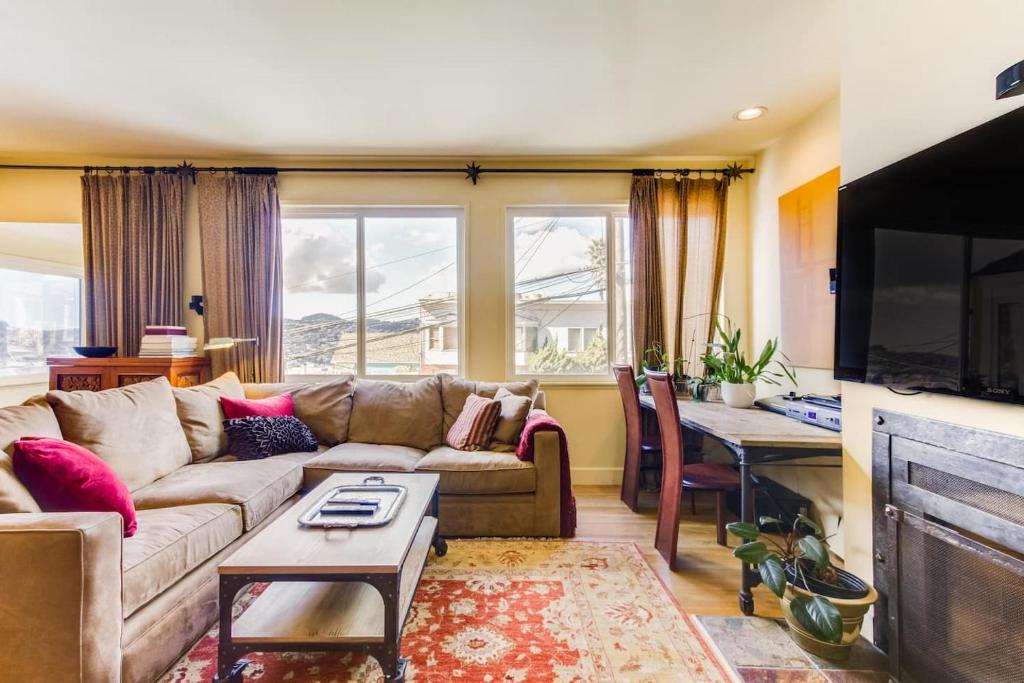 ein Wohnzimmer mit einem Sofa und einem Tisch in der Unterkunft Two Bedroom, Two Newly Renovated Bathrooms, Deck in San Francisco