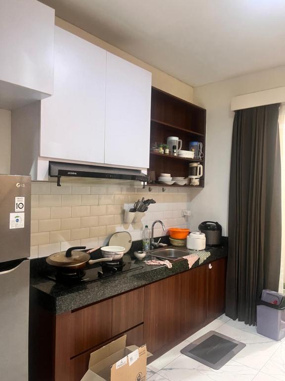 a kitchen with white cabinets and a counter top at Semayang Asya in Jakarta