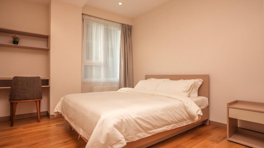 1 dormitorio con cama blanca y ventana en May Seven Hotel en Ulán Bator
