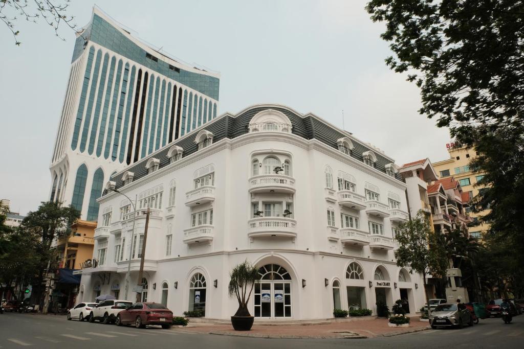 a white building with cars parked in front of it at Paul Chabot Hotel in Hai Phong