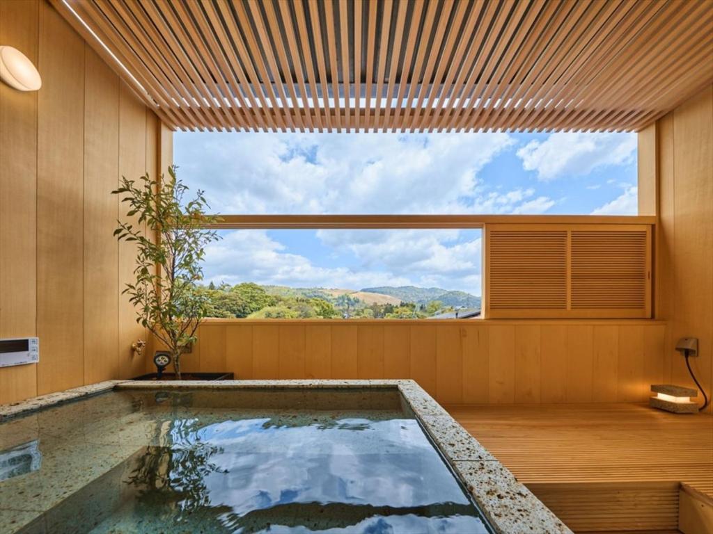 a swimming pool in a house with a large window at Hotel New Wakasa in Nara