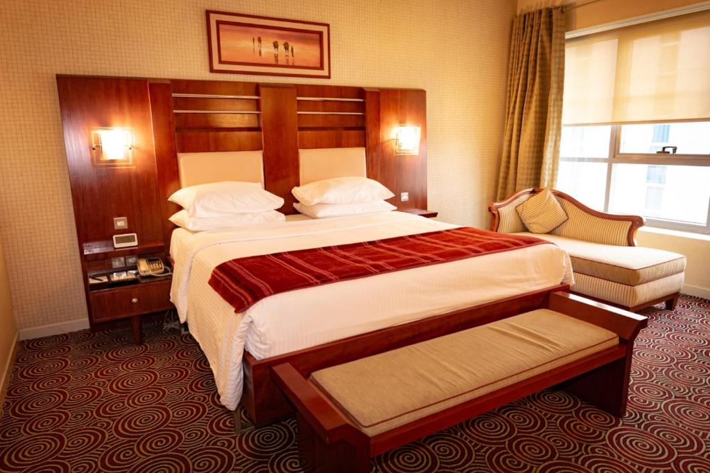 a hotel room with a large bed and a window at Grand Central Hotel in Dubai