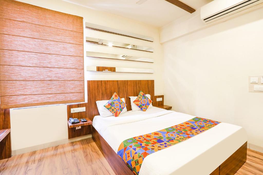 海得拉巴的住宿－FabHotel Arastu，卧室配有一张带彩色枕头的大型白色床。