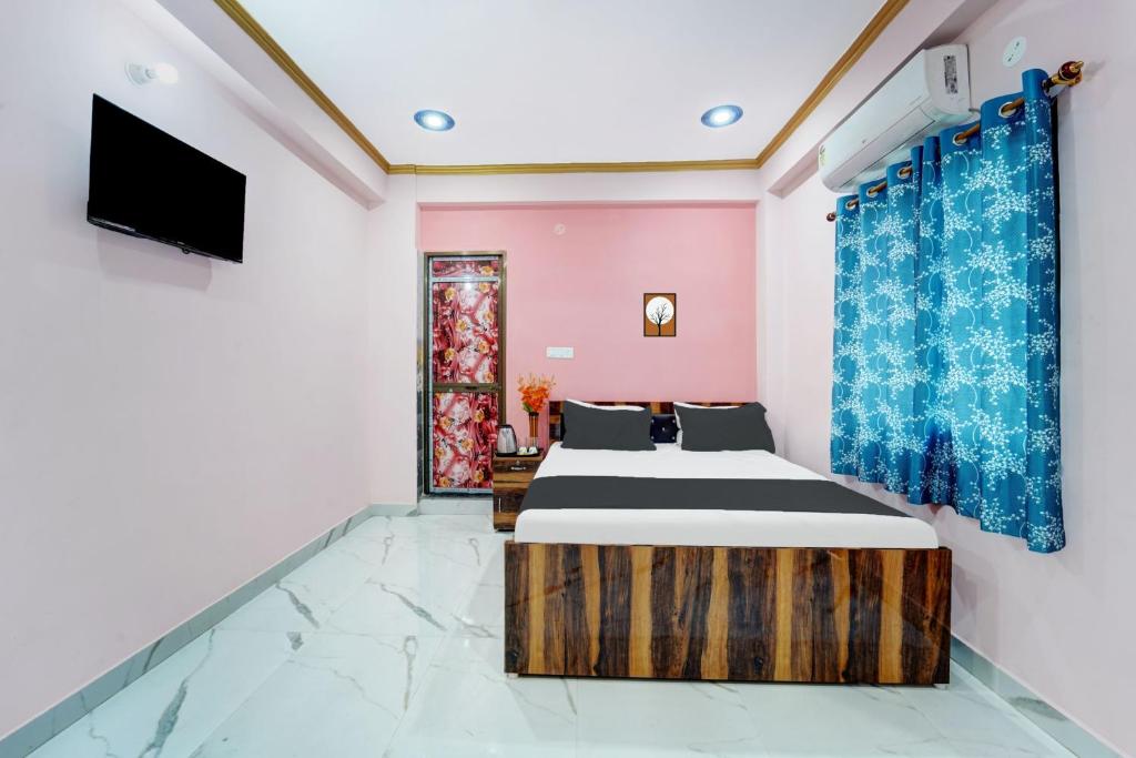 BihtaにあるOYO Flagship R K Marriage Hall and Guest Houseのベッド2台とテレビが備わる客室です。