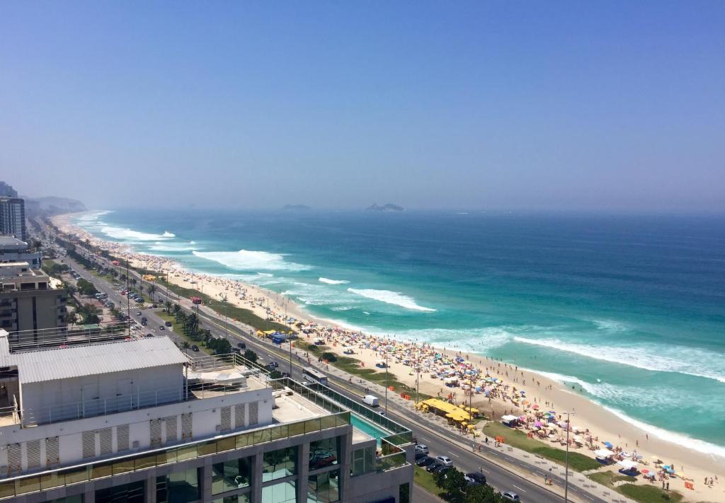 a beach with a lot of people and the ocean at Windsor Marapendi Hotel in Rio de Janeiro