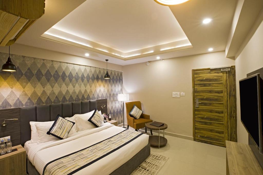 新德里的住宿－Hotel Golden At Delhi Airport，配有一张床和一把椅子的酒店客房