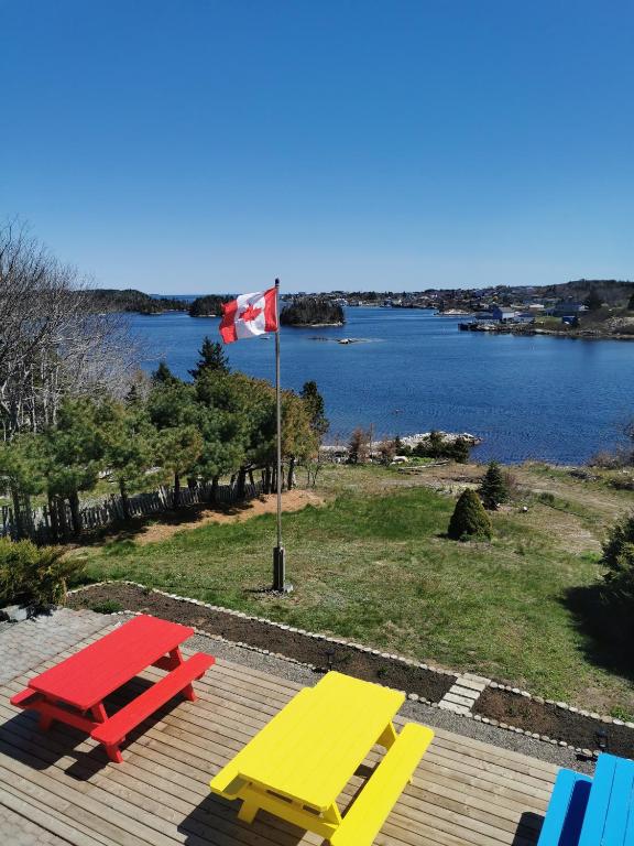 a yellow and red picnic table and a flag on a deck at 181 Oceanside Inn in Peggy's Cove