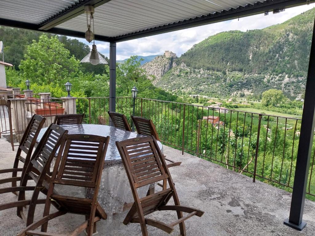 un tavolo e sedie su un balcone con vista di Domyv'Loup a Entrevaux