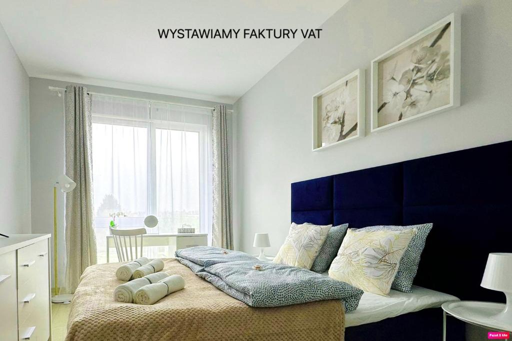 une chambre avec un grand lit et une tête de lit bleue dans l'établissement Premium Apartment - Orchidea, à Rzeszów