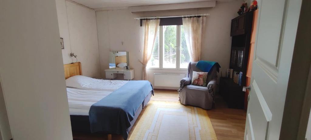 a small bedroom with a bed and a window at Vacation House Kommee Kurki in Sastamala