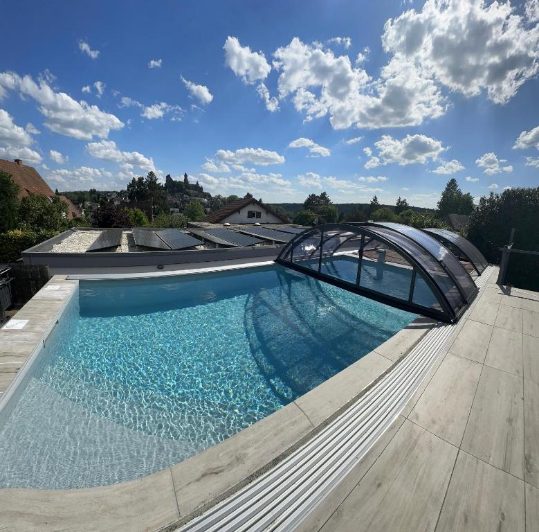 a swimming pool with a glass roof on a house at Ferienwohnung Schlossblick - 4 Sterne Sauna Pool Whirlpool privat in Braunfels