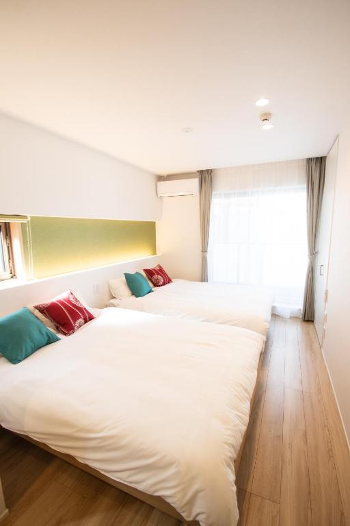 Postel nebo postele na pokoji v ubytování Apartment Hotel Tenjin TUMUGU